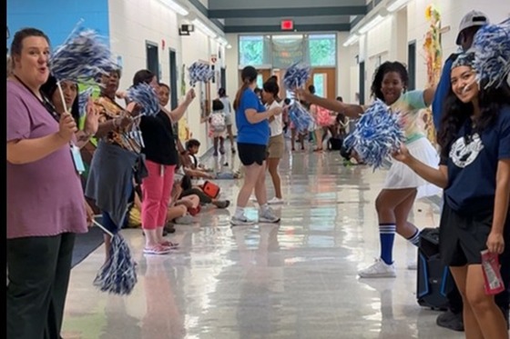 Staff members with pom-poms waiting for students in the main lobby