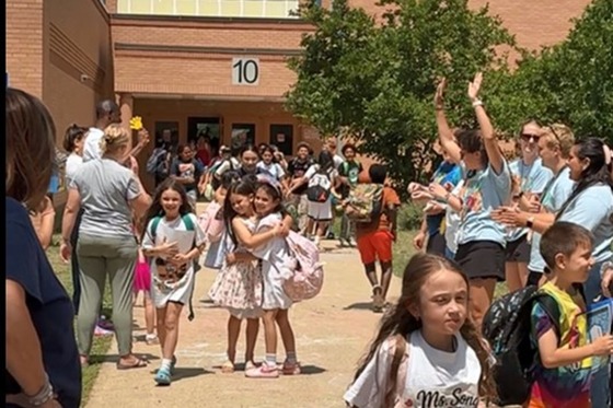 Students hugging each other as they walk to the buses