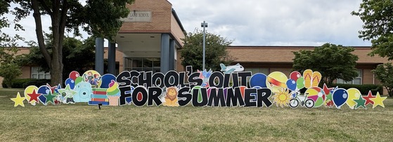 Lawn sign in front of the school that says "School's Out for the Summer"