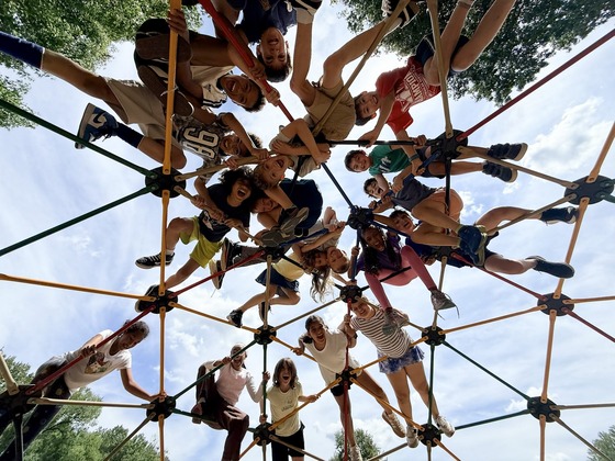 students on top of dome playground equipment