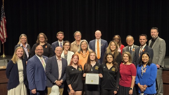image of girls wrestling team at school board meeting