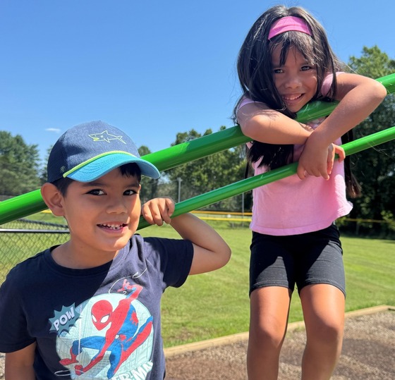Two friends playing together on the playground equipment