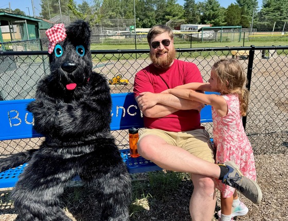 Scottie mascot sitting on a bench with a family