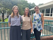 Mrs. Kaplan, Mrs. Lin, and Mrs. Burke standing in the courtyard