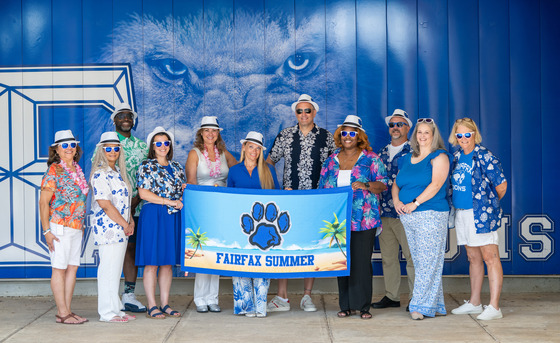 A group of people wearing summer gear posing for a picture