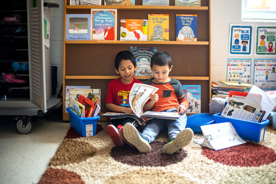 two students reading a book together