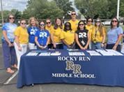 Rocky Run staff members behind a table that says "Rocky Run Middle School" at recent community visits