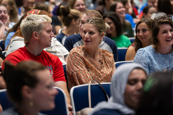 Teachers turn and talk in an auditorium.