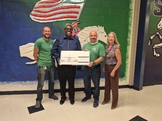 Capitol Petroleum  giving a check to school