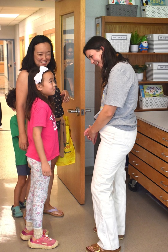 A picture of Mrs. Shope greeting one of her new students during Open House
