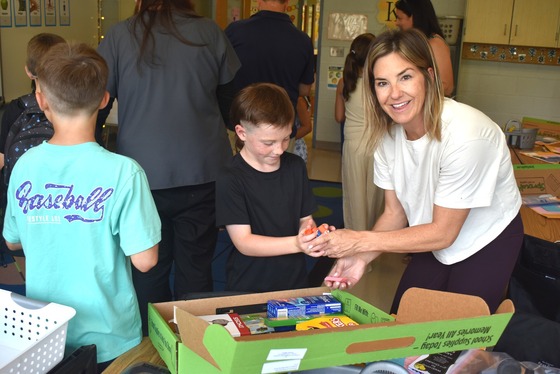 A picture of a student and their parent excitedly unpacking their Sprout's Supply Kit during Open House