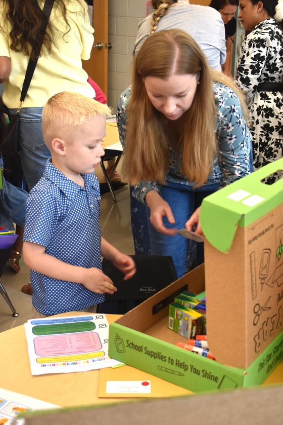 A picture of a student and parent unpacking school supplies from the Sprout's Supply Kit during Open House