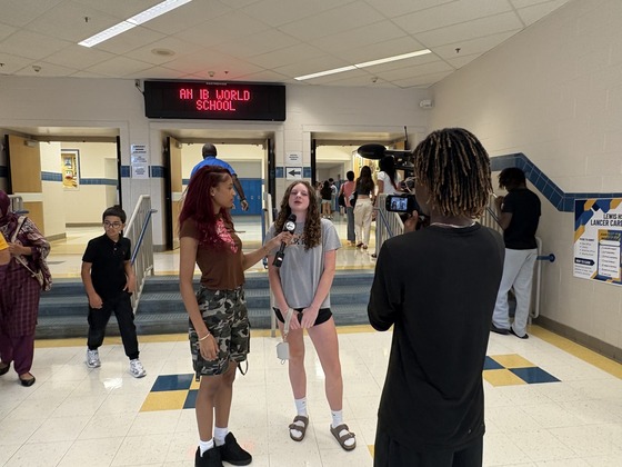 Capturing student conducting interview on camera with a classmate.
