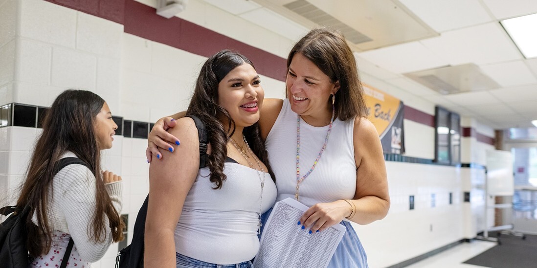 Happy student and teacher in the hallway.