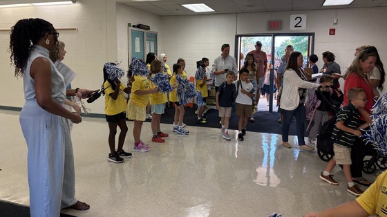Student Ambassadors with pom poms forming a cheering squad as students arrived