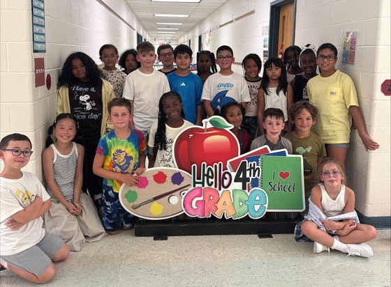 Mrs. Barbiere's 4th grade class taking a picture near the "Welcome to 4th Grade" sign