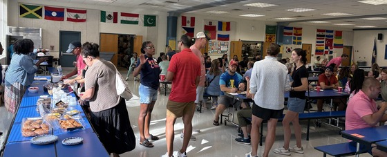 Parents chatting and enjoying coffee and pastries in the cafeteria