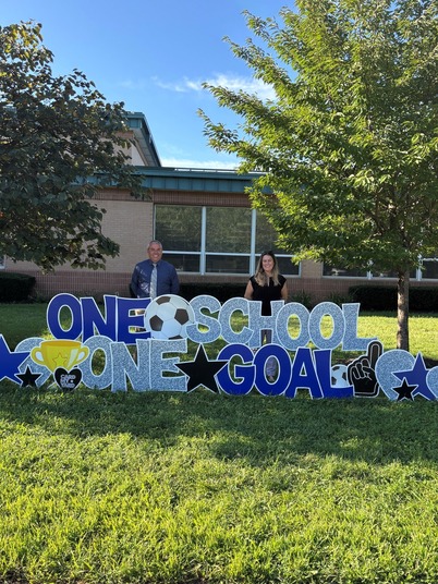 one school one goal sign with principal and asst principal