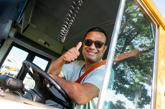 Bus driver gives a thumbs up from the driver's seat