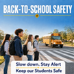 Students waiting to cross a street at a crosswalk with a school bus in the background