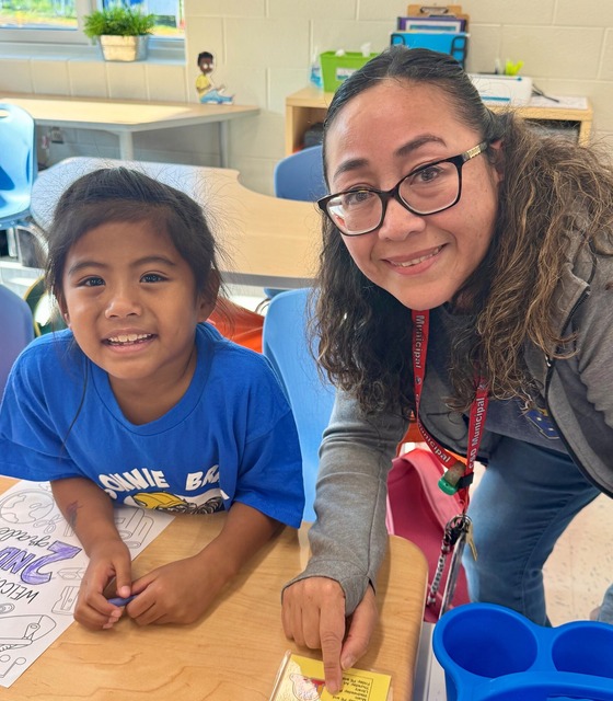 Student with a teacher sitting at a desk