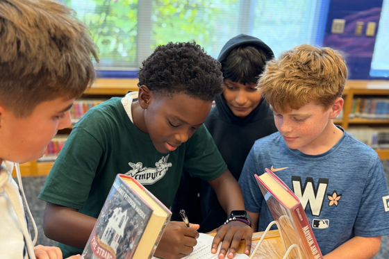 7th grade boys collaborate on a library scavenger hunt