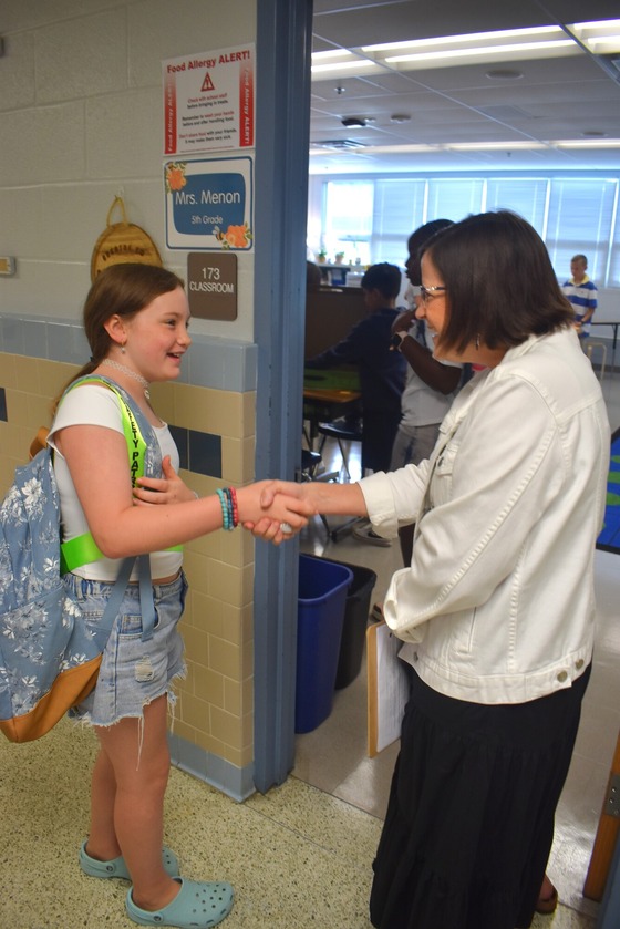 Mrs. Menon greeting a student