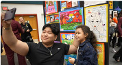 students in front of their artwork
