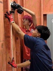 Students drill into the wall in Electrical class