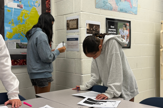students work on the gallery walk project in a classroom