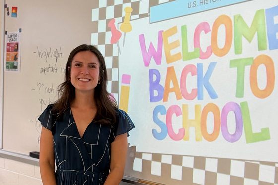 Ms. Suraci standing in front a welcome back to school presentation