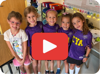 A group of 2nd smiling grade girls standing together to show off their Jersey Day outfits