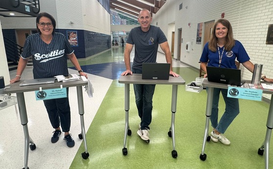 three admin with their rolling desks