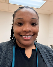 Photo of Mrs. Gore smiling, wearing a black shirt and blue lanyard