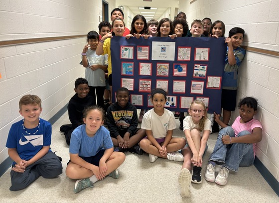 Students with their commemorative "quilt" commemorating the heroes and victims of 9/11