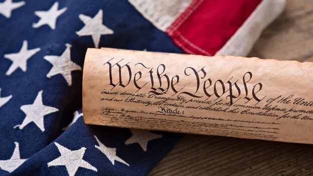 American Flag with a parchment of the Constitution