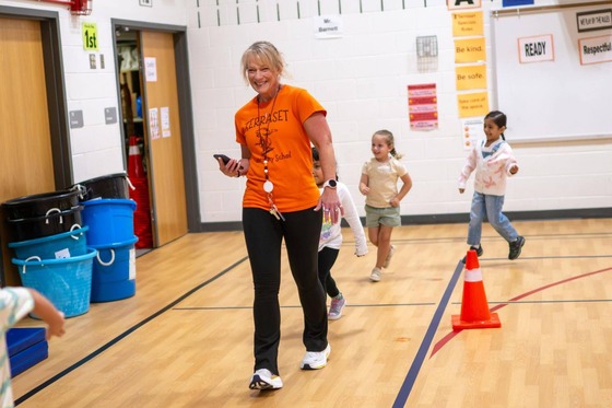 teacher dances with students in PE class