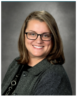 a female wearing black and gray and glasses, smiling.png