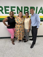Four members of Greenbriar East’s administrative team smile together in a school hallway.