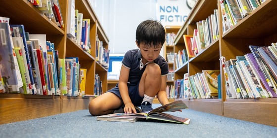 student reading a book in the library