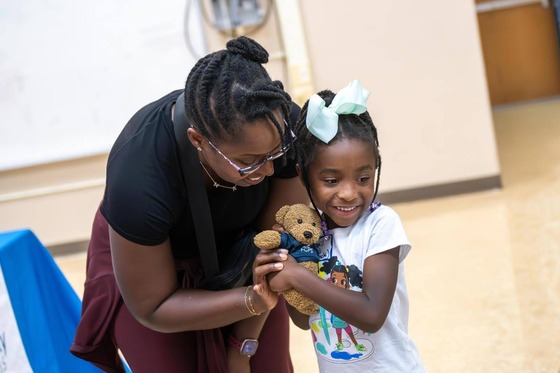 student hugging a teddy bear