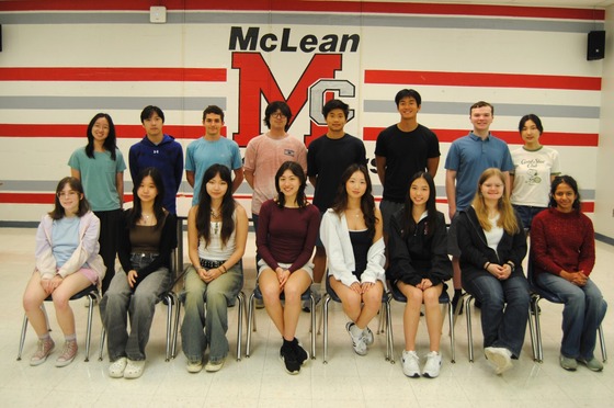 A group portrait of 16 high school students arranged in two rows in front of a McLean High School wall logo.