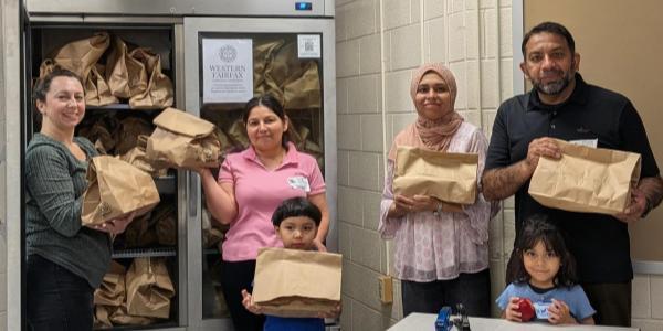 Adults and kids working as Fresh Pack Volunteers