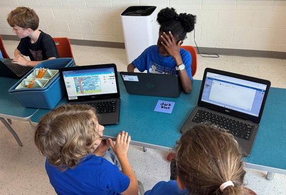Students collaborating while on the computer