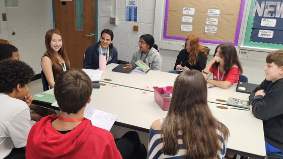 Students sitting around a table interviewing Ms. Padilla
