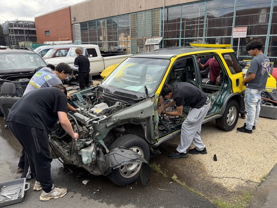 Auto Collision students tearing down a vehicle