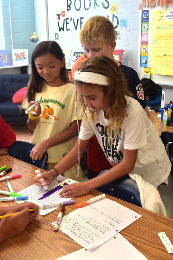 A picture of 3 students working together on a math project