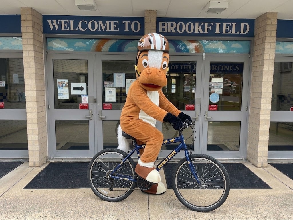 Buddy Bronco, our mascot, riding a bike in front of our school
