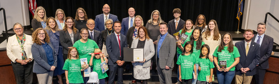 FCPS School Board in front of the dais with those attending to celebrate the National Literacy Month proclamation