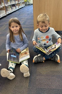 picture of two kids reading in the library
